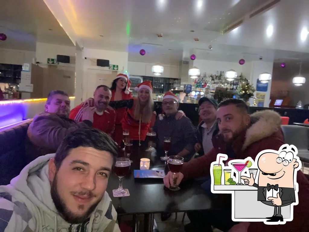 intérieur chaleureux du Phoenix Bar à Payerne avec tables, bar et lumière rouge tamisée