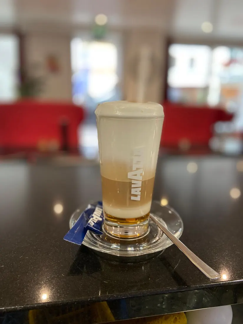 boisson servie dans un grand verre au Phoenix Bar à Payerne, mousse crémeuse sur couches ambrées